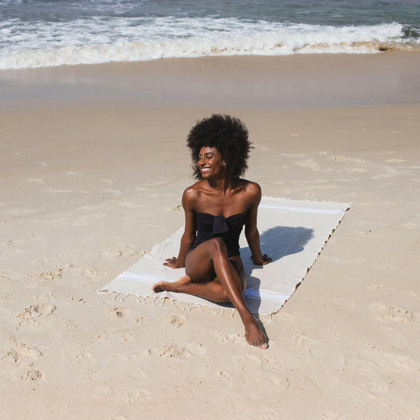 Femme allongée sur une fouta de plage couleur sahara - BY FOUTAS