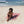 Femme allongée sur une fouta de plage couleur rose poudré - BY FOUTAS