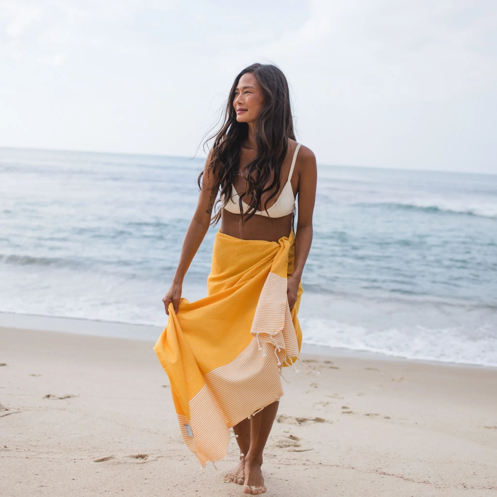 Woman using a Yellow Mustard Honeycomb Fouta - BY FOUTAS