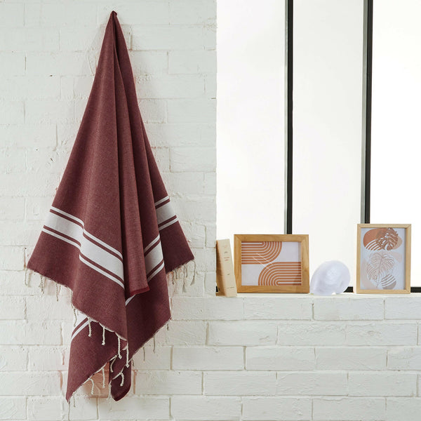 fouta flat weave color burgundy hanging in a bathroom - BY FOUTAS