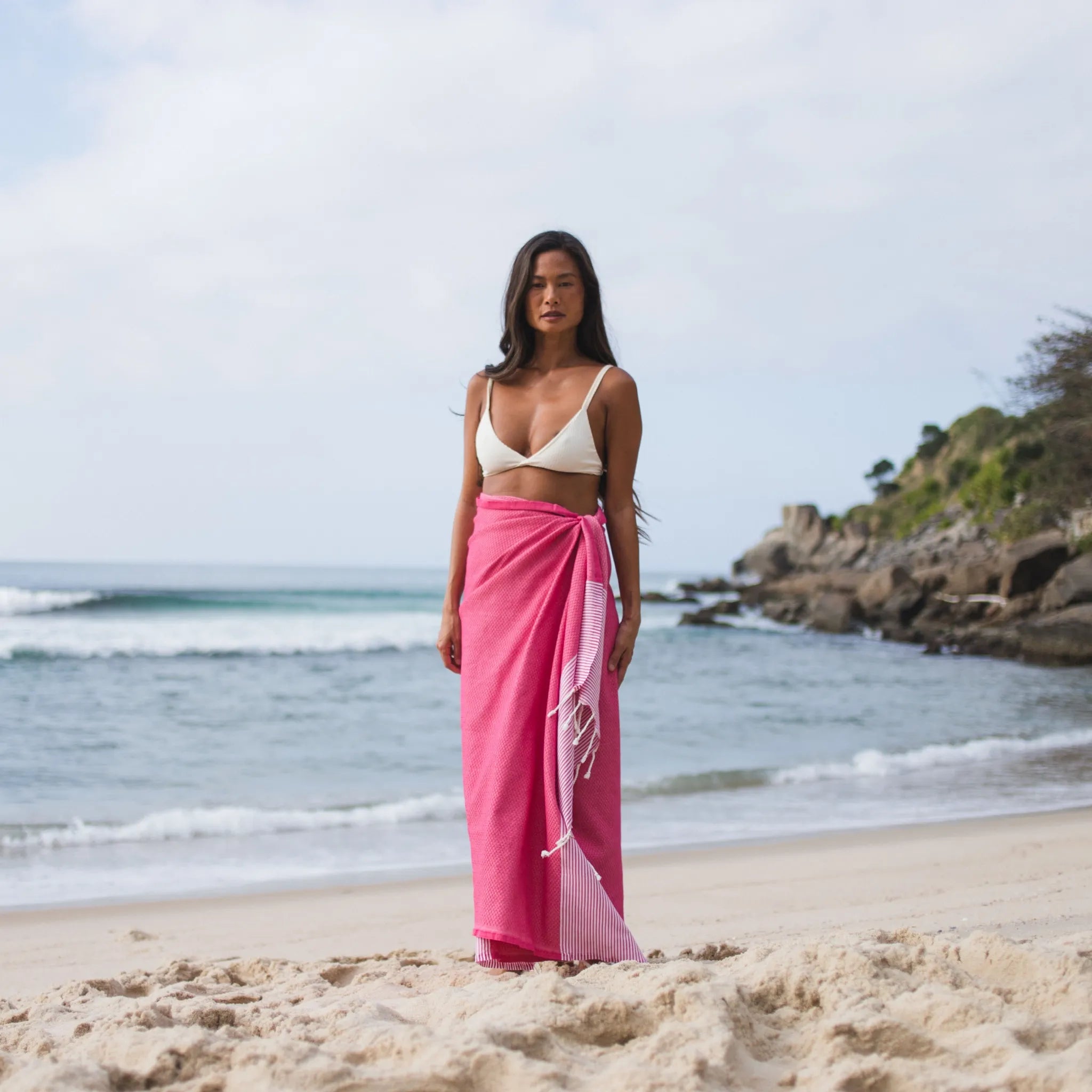 Donna che usa una Fouta a nido d'ape fucsia - BY FOUTAS