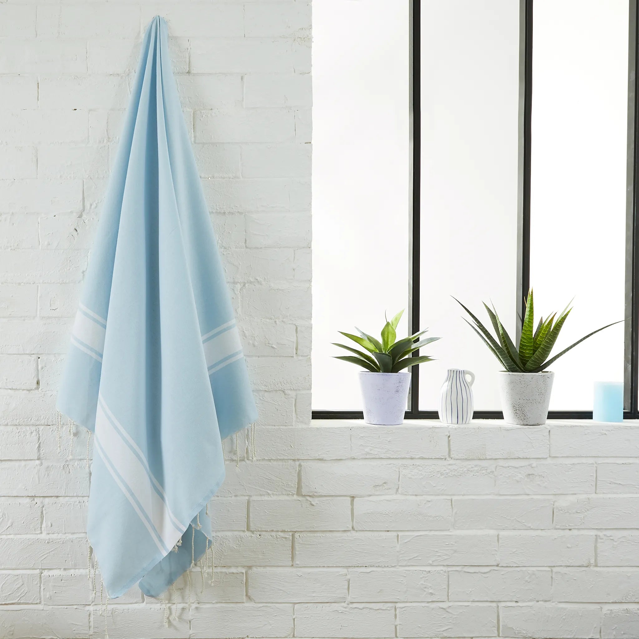 Femme utilisant une Fouta Classique Bleu Ciel - BY FOUTAS