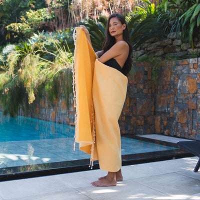 Woman using a Mustard Yellow Terry lined Fouta - BY FOUTAS