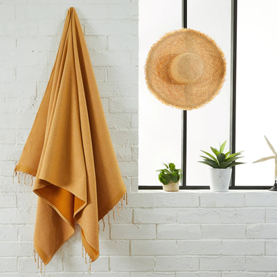 Woman using a Mustard Yellow Terry lined Fouta - BY FOUTAS