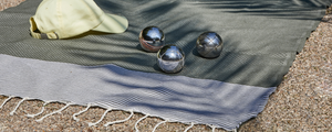 fouta honeycomb olive placed on gravel with petanque balls