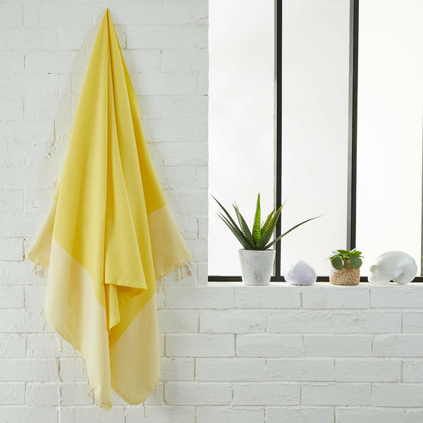fouta Nid d’abeille couleur jaune citron suspendue dans une salle de bain - BY FOUTAS