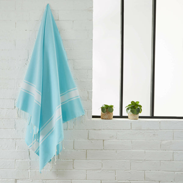 fouta flat weave aqua color hanging in a bathroom - BY FOUTAS