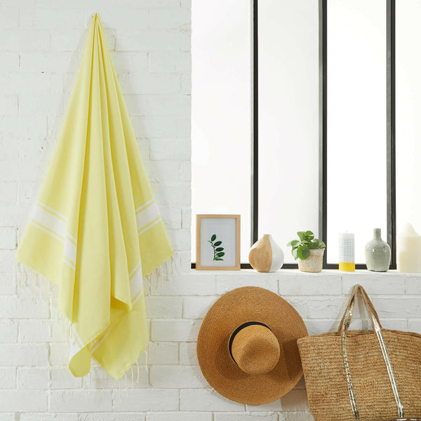 fouta Tissage plat couleur jaune citron suspendue dans une salle de bain - BY FOUTAS