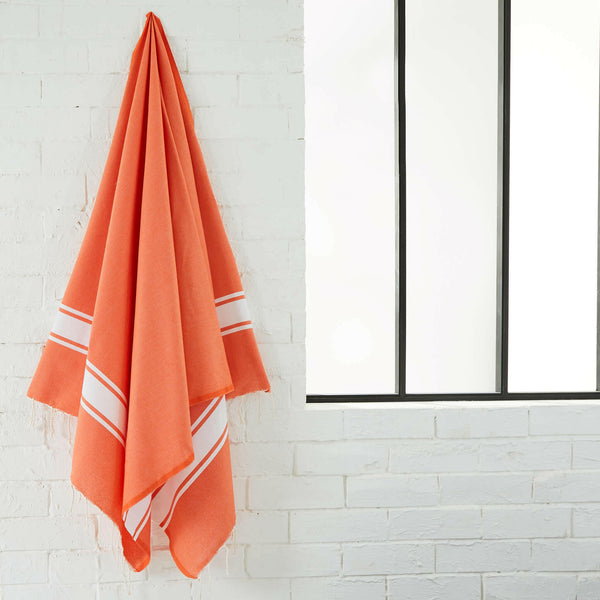 fouta flat weave orange color hanging in a bathroom - BY FOUTAS