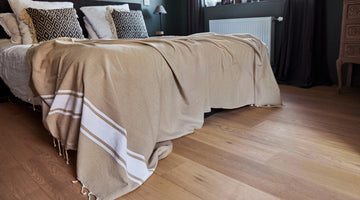 Taupe-colored Fouta used as a bed throw in a bedroom - BY FOUTAS