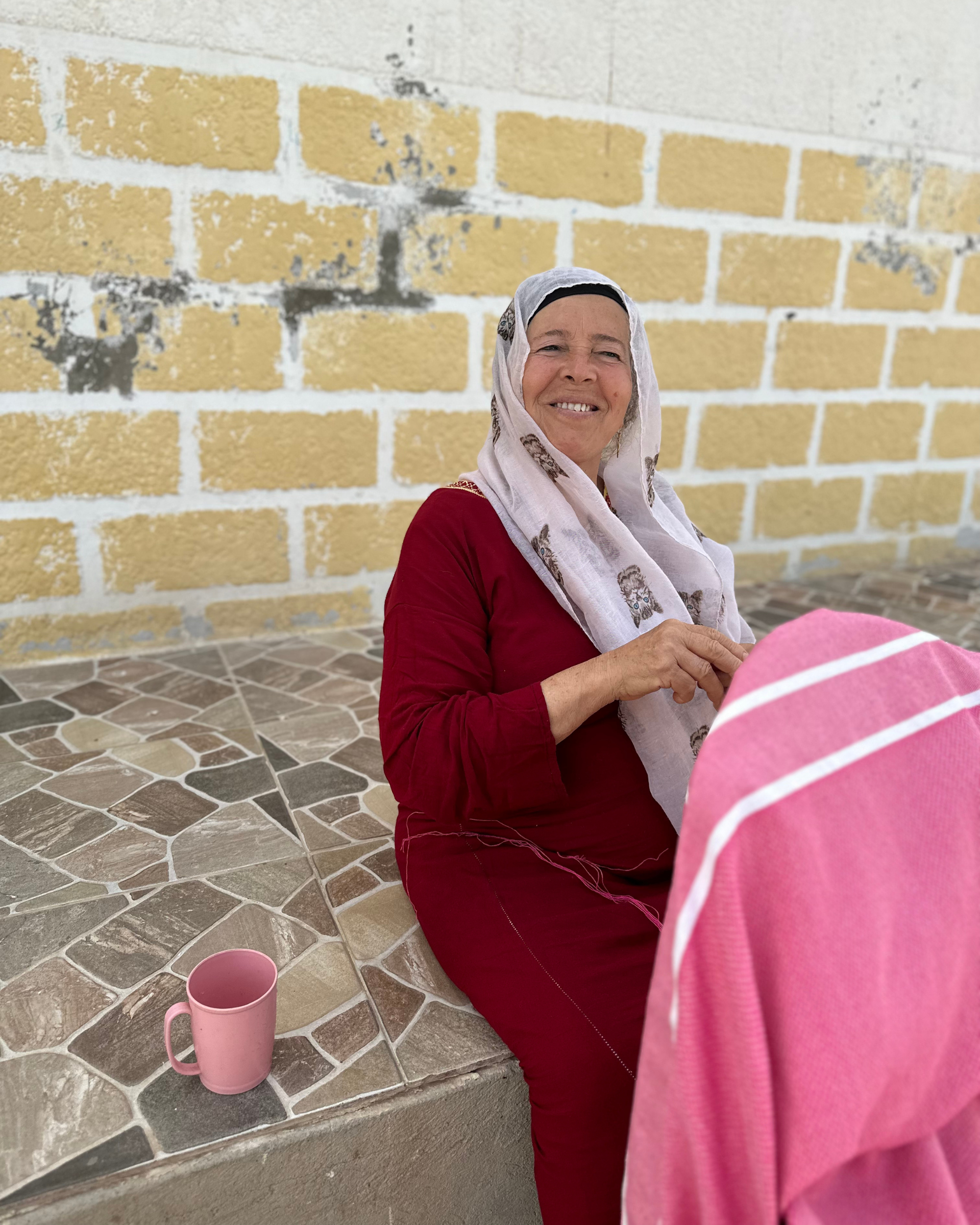 Craftswoman on the pediment of her house tying fouta bangs - BY FOUTAS