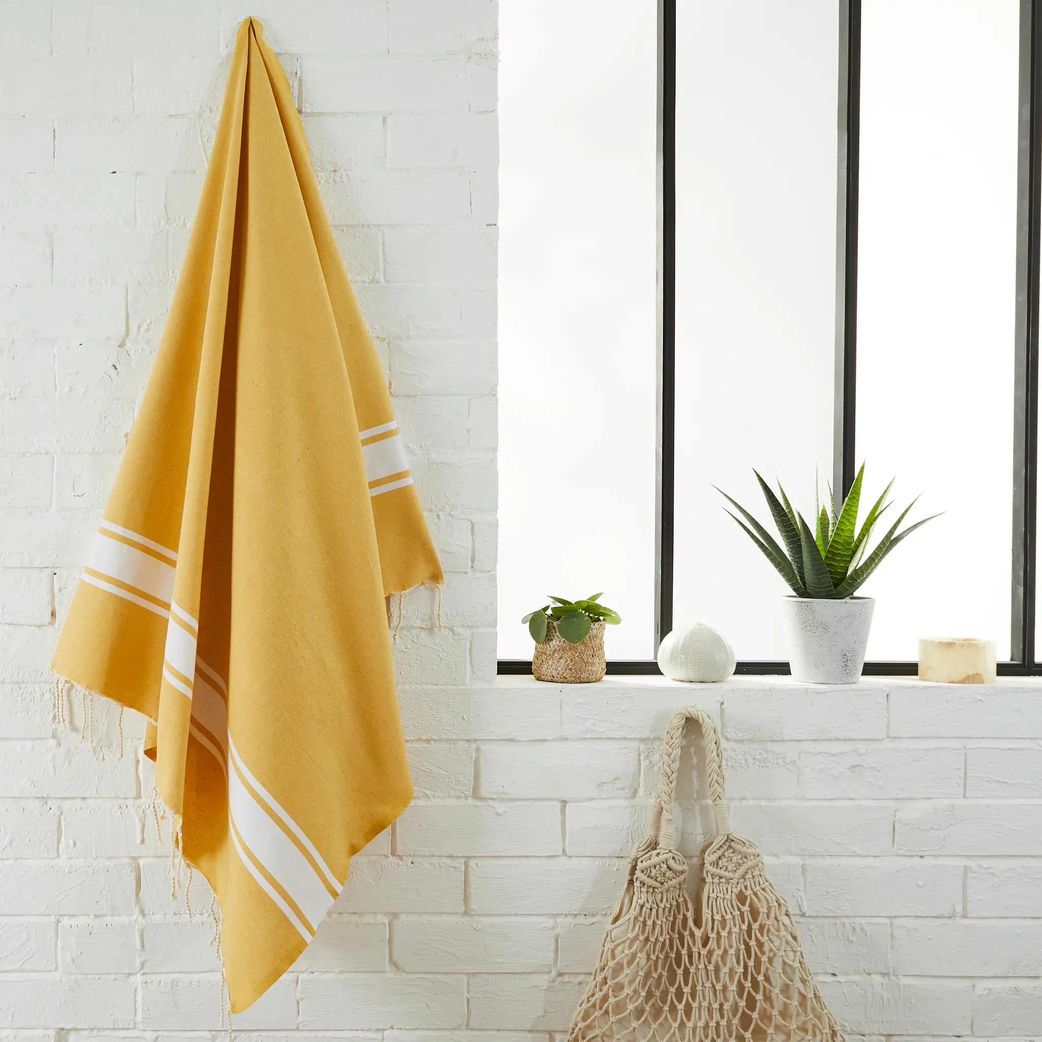 Woman using a Classic Yellow Mustard Fouta - BY FOUTAS