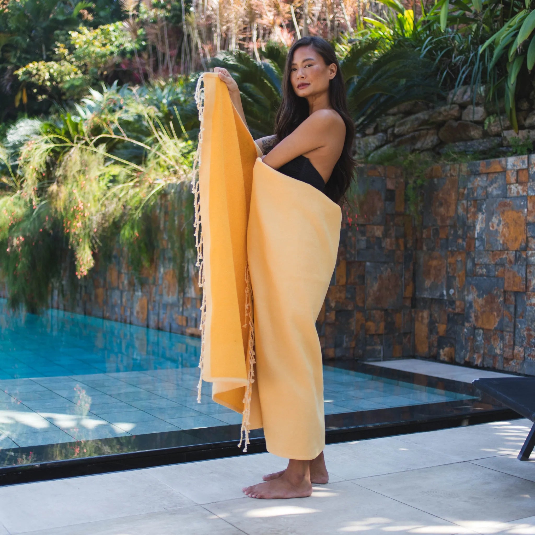 Woman using a Mustard Yellow Sponge Fouta - BY FOUTAS