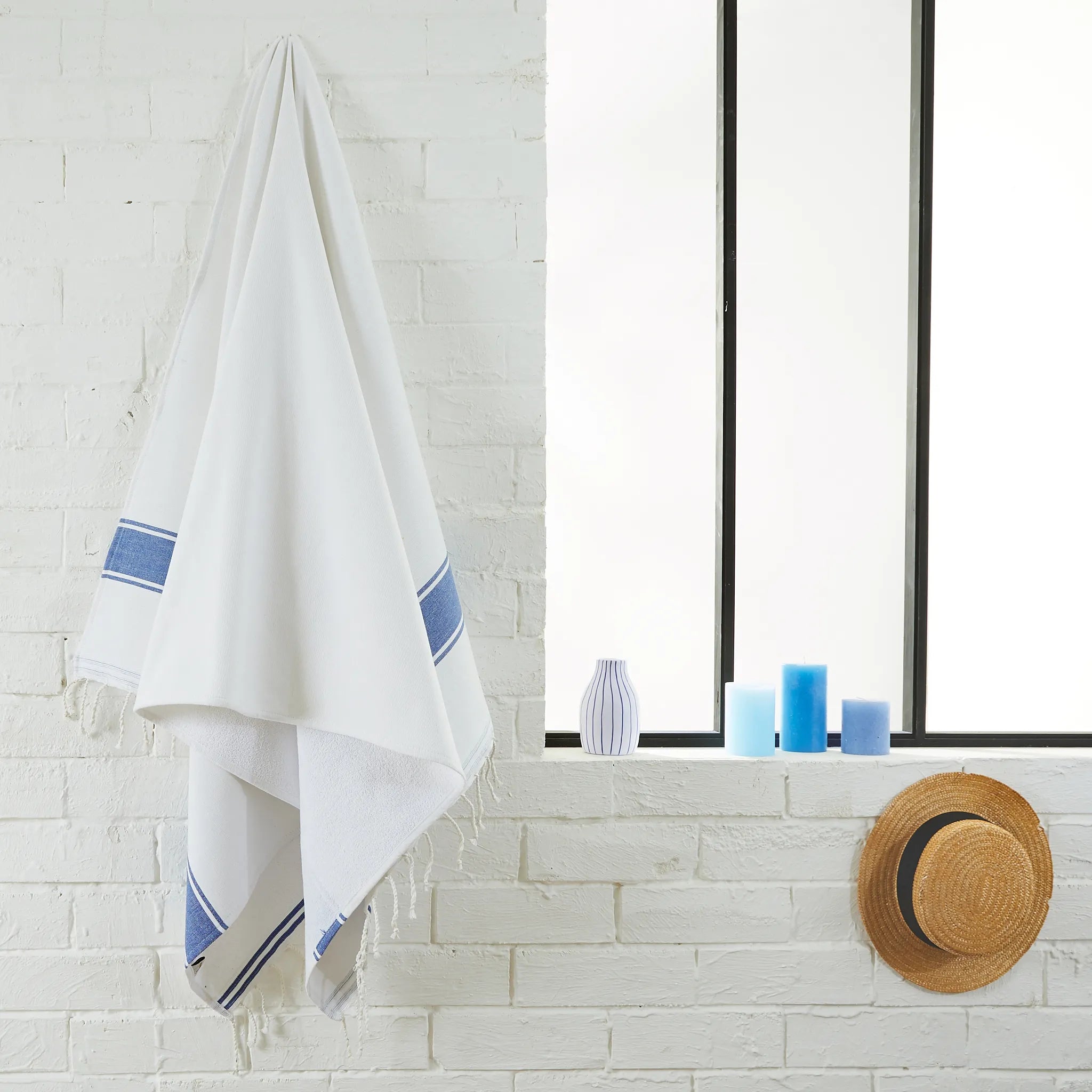 Woman using a White/Ocean Blue Sponge Fouta - BY FOUTAS