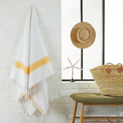 Woman using a White/Jellow Mustard Fouta - BY FOUTAS