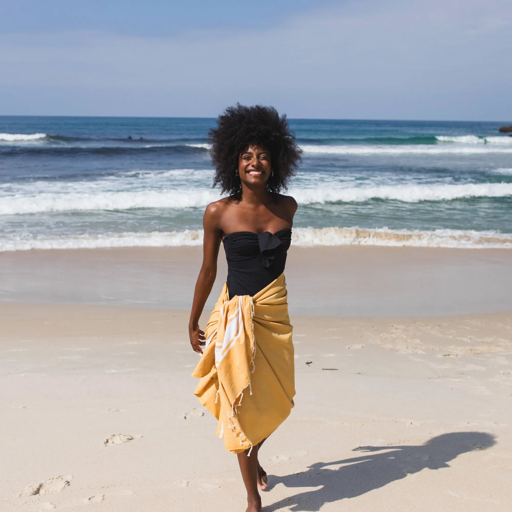 Woman using a yellow fouta as a sarong - BY FOUTAS