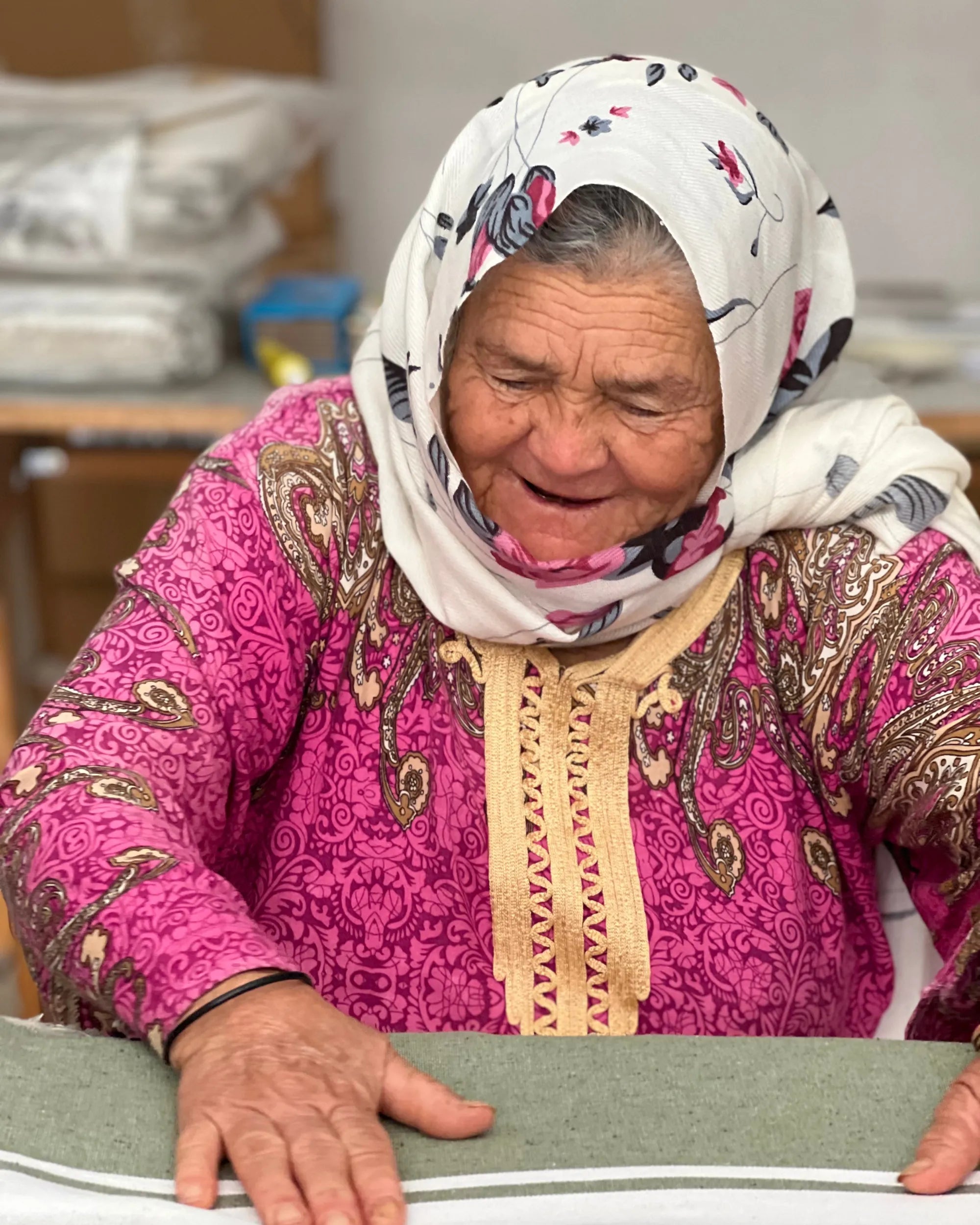 Tunisian craftswoman folding a fouta - BY FOUTAS