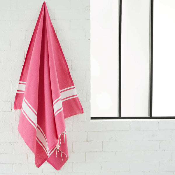 fouta tejido plano color fucsia colgado en un cuarto de baño - BY FOUTAS