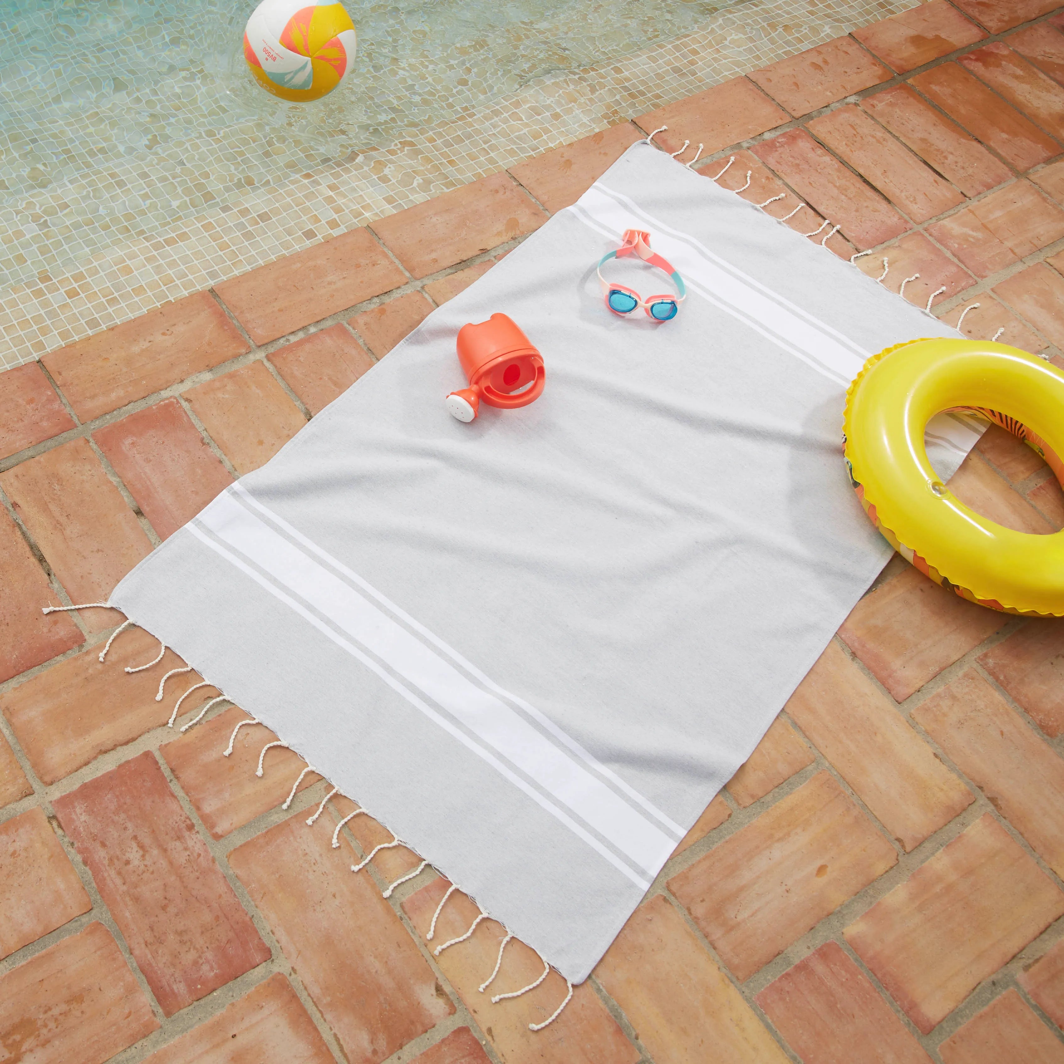 Donna che utilizza un Fouta personalizzabile per bambini di colore grigio chiaro BY FOUTAS